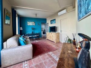 a living room with blue walls and a couch at Appartement Jardin exotique in Cap d'Ail