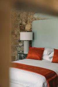 a bed with red and white pillows and a brick wall at The Forge in Swansea +8 photos