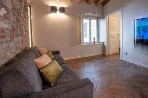 Una sala de estar con un sofá y una pared de piedra. en ARTLOFT Charme&Relax, en Bérgamo
