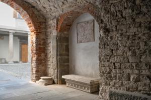 un arco de piedra con un banco en una pared de ladrillo en ARTLOFT Charme&Relax, en Bérgamo