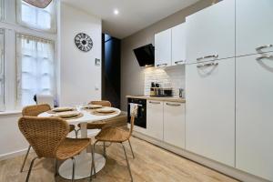 a kitchen and dining room with a table and chairs at Appartement Central et Tout Equipé - 2 - Mon Groom in Troyes