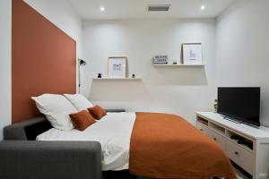 a bedroom with a bed and a flat screen tv at Appartement Central et Tout Equipé - 2 - Mon Groom in Troyes