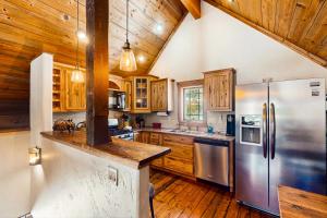 a kitchen with wooden cabinets and a stainless steel refrigerator at Shadow Mountain Marina in Grand Lake