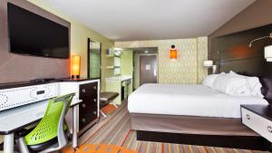 um quarto de hotel com uma cama e uma secretária com um computador em Holiday Inn Express Atlanta Galleria-Ballpark Area, an IHG Hotel em Atlanta