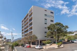 a white building with cars parked in front of it at Amparo II by An Island Apart in Funchal