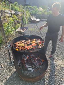 a man is cooking food on a grill at Breighof in Biberach bei Offenburg