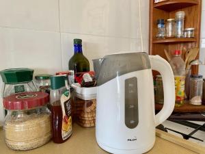 a white mixer sitting on a kitchen counter with ingredients at חדר בדירה במצפה רמון in Mitzpe Ramon