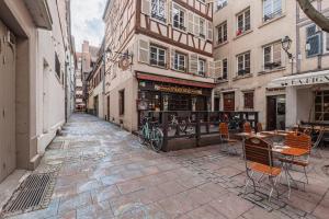 Un callejón con mesas y sillas en una calle en Le Cosy Stras - Studio hyper centre, en Estrasburgo