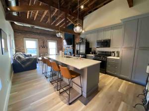 a kitchen with a large white island with bar stools at Condo in OTR, Pendleton Art District in Cincinnati +4 photos
