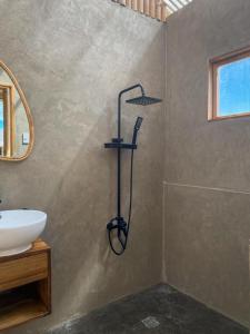 a shower in a bathroom with a sink at Glamping at Kalumo Lodge - Tent 1 in Oslob