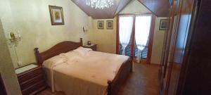 a bedroom with a bed and a chandelier at Casa IL GLICINE in Camporosso