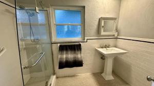 a white bathroom with a sink and a shower at The Nest in Gainesville +10 photos
