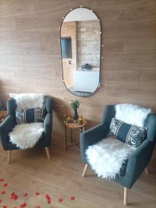 a living room with two chairs and a mirror at L'Eden in Gréolières
