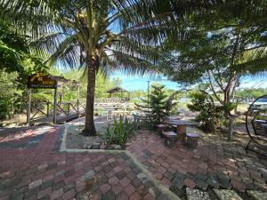 a patio with a table and a palm tree at Rumah Tepi Sungai KB in Kota Bharu