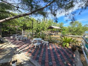 a group of tables and chairs on a brick patio at Rumah Tepi Sungai KB in Kota Bharu