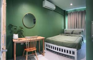 a bedroom with a bed and a table and a mirror at Midori Rawai Hotel in Ban Saiyuan (1)