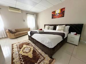 a bedroom with a large bed and a couch at Kilimanjaro Lodge in Johannesburg