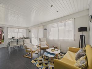 ein Wohnzimmer mit Sofa, Stühlen und einem Tisch in der Unterkunft Maison pour 8 - Terrasse - Barbecue - 500 m plage in Brétignolles-sur-Mer