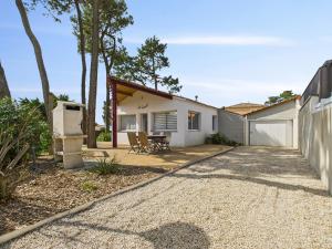 ein Haus mit einer Terrasse und einem Zaun in der Unterkunft Maison pour 8 - Terrasse - Barbecue - 500 m plage in Brétignolles-sur-Mer