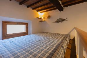a bedroom with a bed in a room with a window at Casa dei Giuggioli - Helloelba in Portoferraio +5 photos