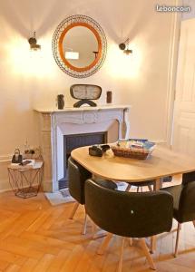Un comedor con mesa y chimenea. en Coquette Suite au Bernascon Appartement 2 étoiles avec avec vue Lac, en Aix-les-Bains