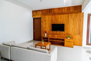un salon avec un canapé et une télévision dans l'établissement Umah Asri, à Ubud