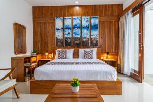 - une chambre avec un grand lit et des murs en bois dans l'établissement Umah Asri, à Ubud 5 autres photos