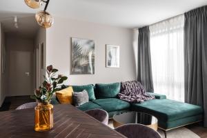 een woonkamer met een groene bank en een tafel bij Scala City Center Apartments with Parking by Lion Apartments in Gdańsk +55 foto's
