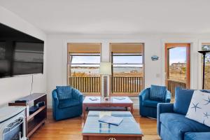 a living room with blue couches and a table at Sweeping Views Minutes to Beach in Chatham