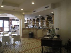 a restaurant with a table and chairs and a kitchen at Hotel Stazione sul lago di Iseo in Paratico