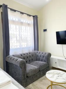 a living room with a couch and a window at Caramel Home in Mombasa