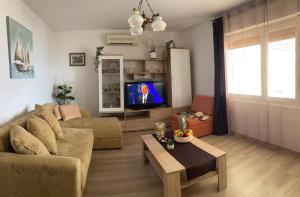 a living room with a couch and a tv at Pisak holiday homes in Pisak