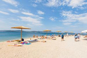 een groep mensen op een strand met parasols bij Apartment Bike Corner in Zadar
