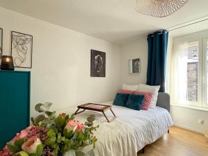 a bedroom with a bed with a table on it at La Bonbonnière Centre ville - Thermes - Netflix in Mont-Dore