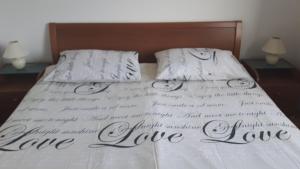 Una cama con dos almohadas con escritura. en Apartment Matea, en Banjole