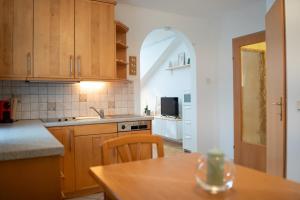 a kitchen with wooden cabinets and a wooden table with a wooden table at Stiglitzer Apartment in Sankt Martin