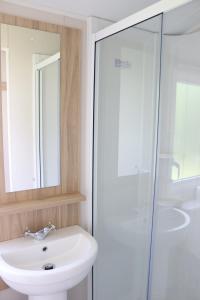 a bathroom with a sink and a glass shower at Ingoldale Holiday Park in Ingoldmells +22 photos