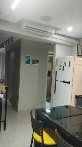 Apto Incrível - Piscina no Rooftop - Vista Mar - 600m Praia Enseada في غوارويا: مطبخ مع طاولة زجاجية وثلاجة