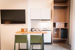 雷焦卡拉布里亚Villa Nina RC的厨房里有一张桌子和两把绿色椅子 更多28张照片