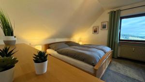 ein Schlafzimmer mit einem Bett und einem Tisch und einem Fenster in der Unterkunft Urlaub mit Talblick in Schönwald im Schwarzwald in Schönwald
