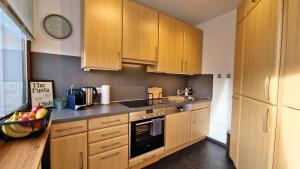 eine Küche mit Holzschränken und einer Schale Obst in der Unterkunft Urlaub mit Talblick in Schönwald im Schwarzwald in Schönwald