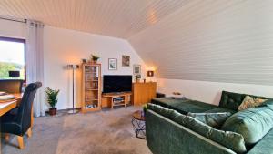 ein Wohnzimmer mit Sofa und Fernseher in der Unterkunft Urlaub mit Talblick in Schönwald im Schwarzwald in Schönwald