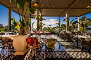 a restaurant with tables and chairs with a view of the ocean at Hotel Riu Palace Tikida Agadir - All Inclusive in Agadir