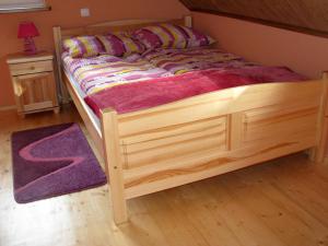 a bed with a wooden frame in a room at Leśne Zacisze in Wünschelburg