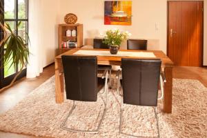 a dining room with a wooden table and black chairs at Haus Oldenburg "unten" in Borkum