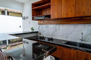 - une cuisine avec des comptoirs en marbre et des placards en bois dans l'établissement Umah Asri, à Ubud