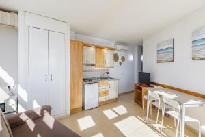 a kitchen and dining room with a table and chairs at Apartamentos Doramar in Benalmádena