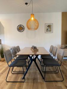 a dining room table with chairs and a light fixture at MeerZeit 20 in Wittmund +19 photos