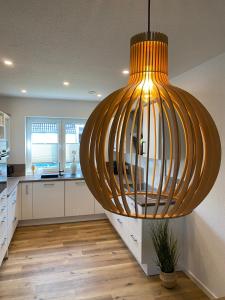 a kitchen with a large chandelier hanging from the ceiling at MeerZeit 20 in Wittmund