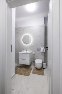 a white bathroom with a toilet and a sink at GPM Home and Stay Apartments in Cluj-Napoca
